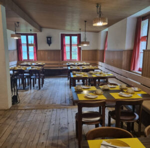 Gemütlicher Gasthof mit gedeckten Tischen und Holzdekor.